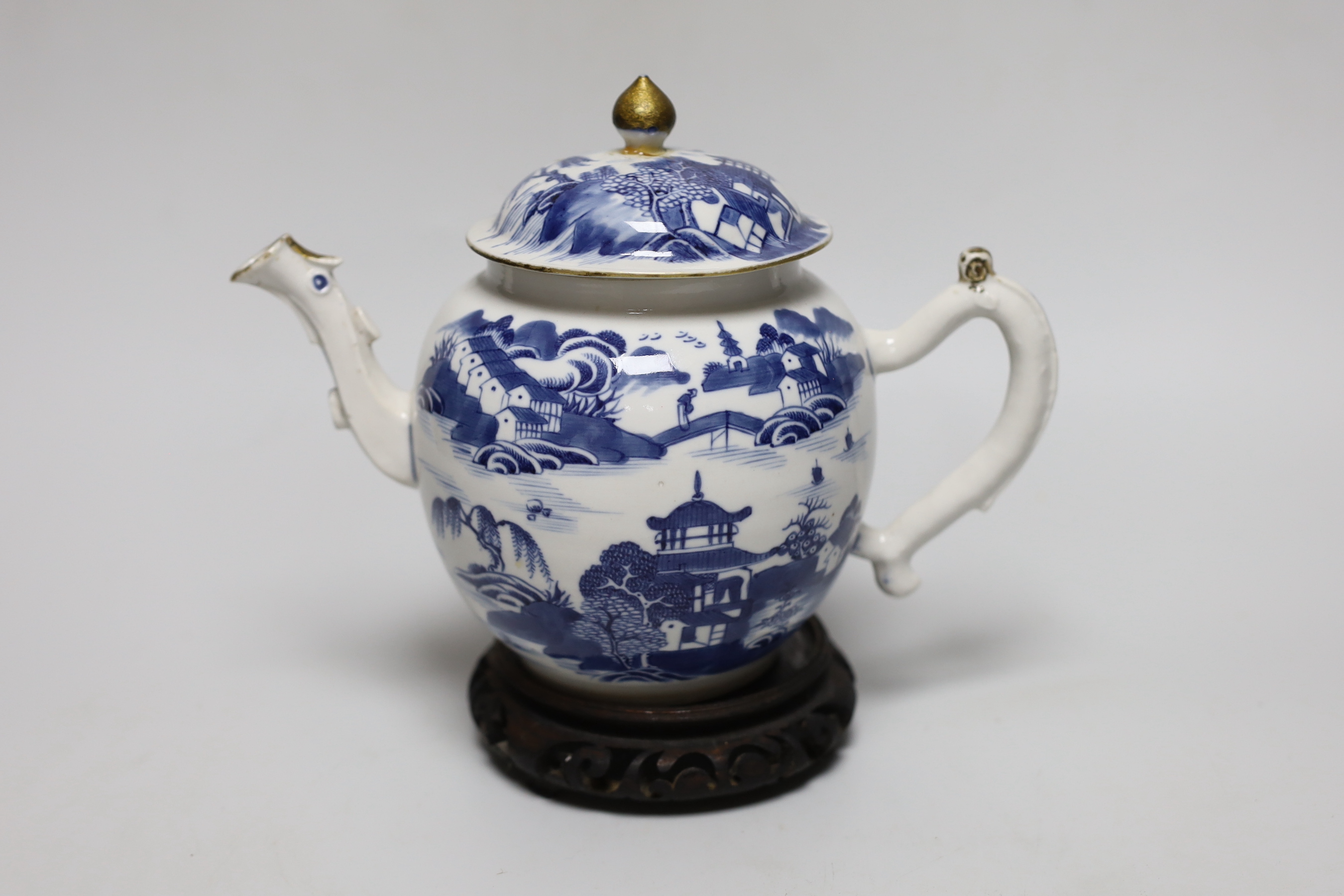 An 18th century Chinese blue and white teapot and cover, with hardwood stand, 19cm total height